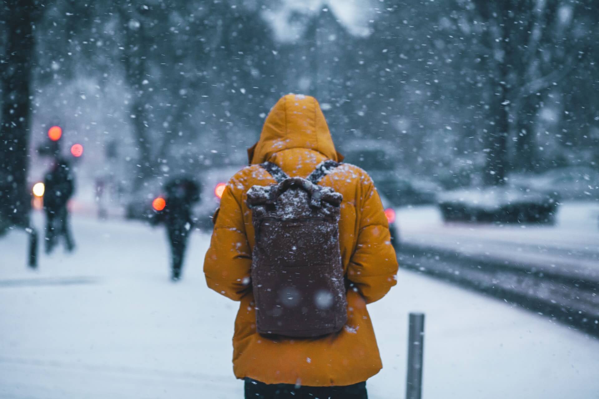 Person in yellow jacket walking in the snow